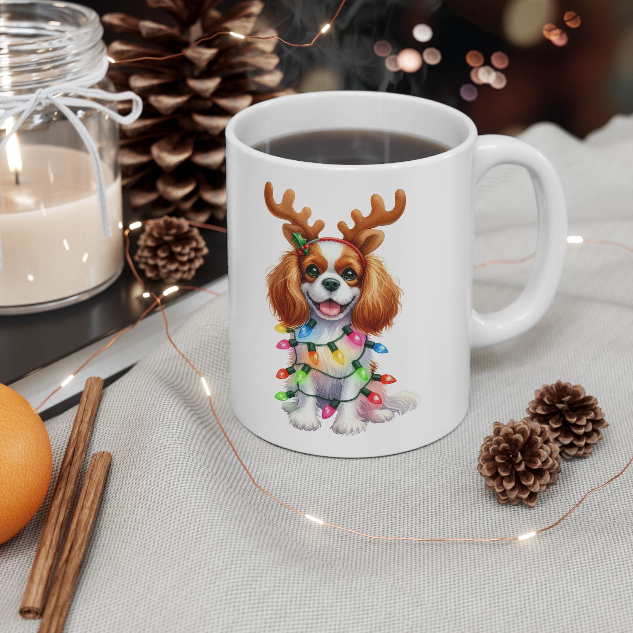 White ceramic mug with a Cavalier King Charles Spaniel wearing reindeer antlers and Christmas lights.