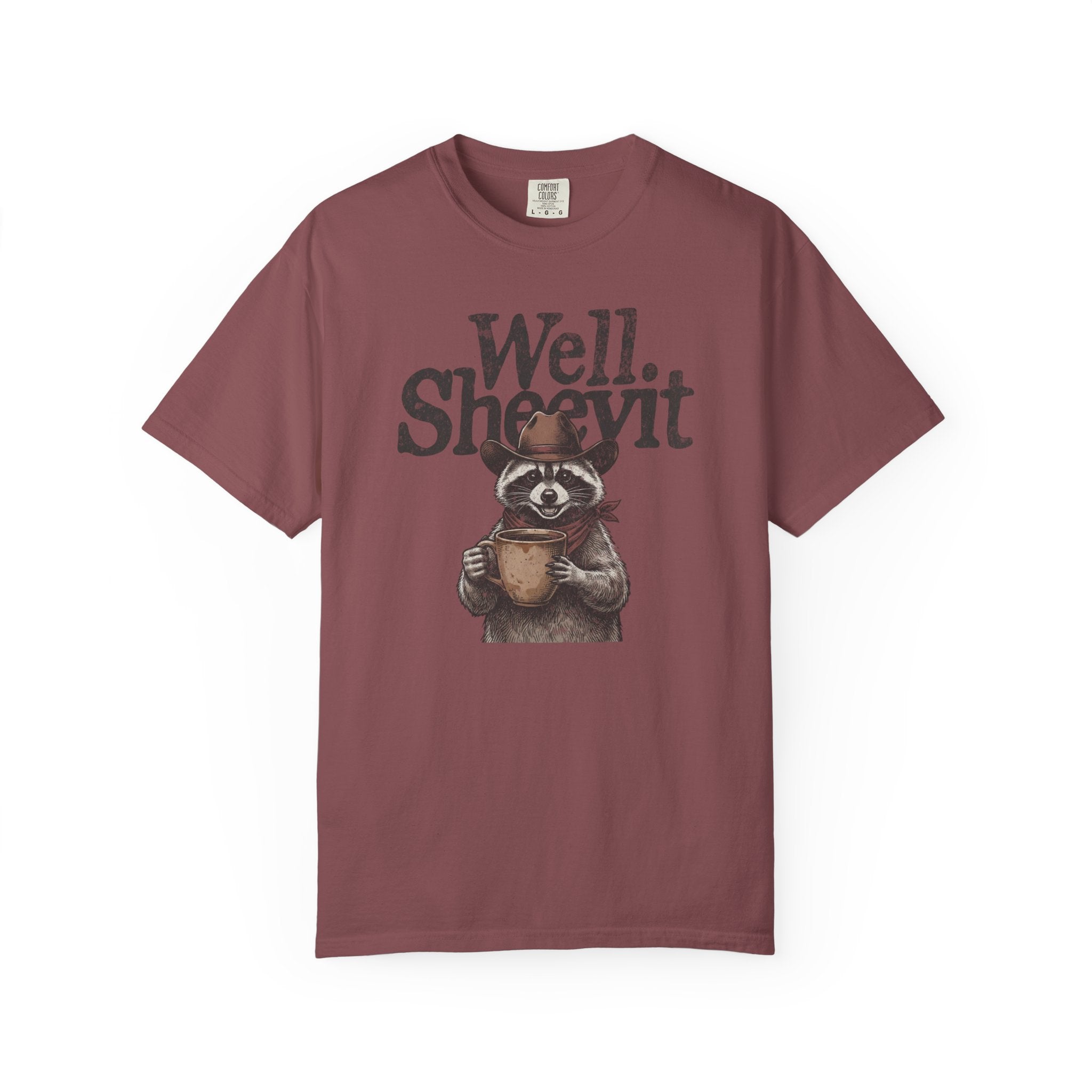 A maroon t-shirt featuring a graphic of a raccoon wearing a cowboy hat and holding a coffee mug.