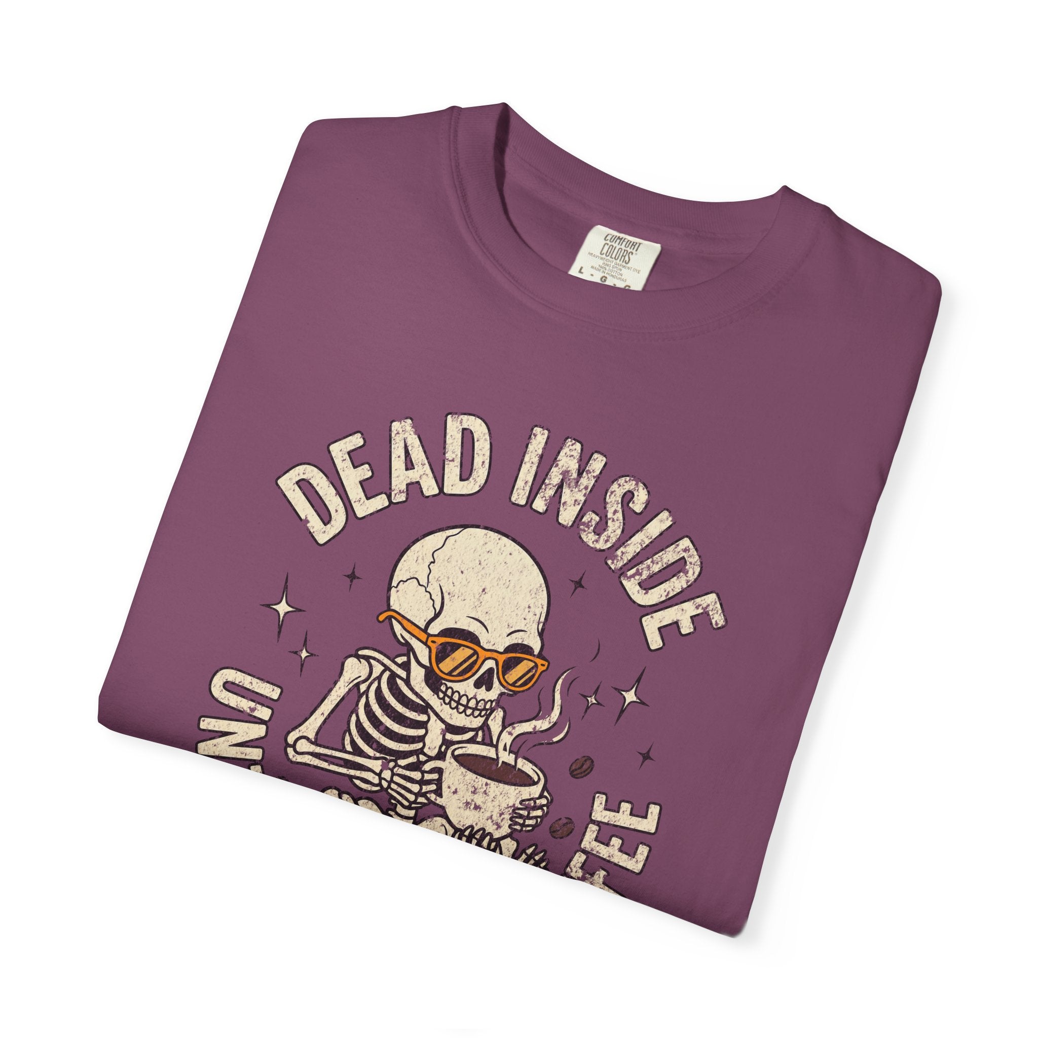 Purple t-shirt with a distressed graphic of a skeleton wearing sunglasses and drinking coffee.
