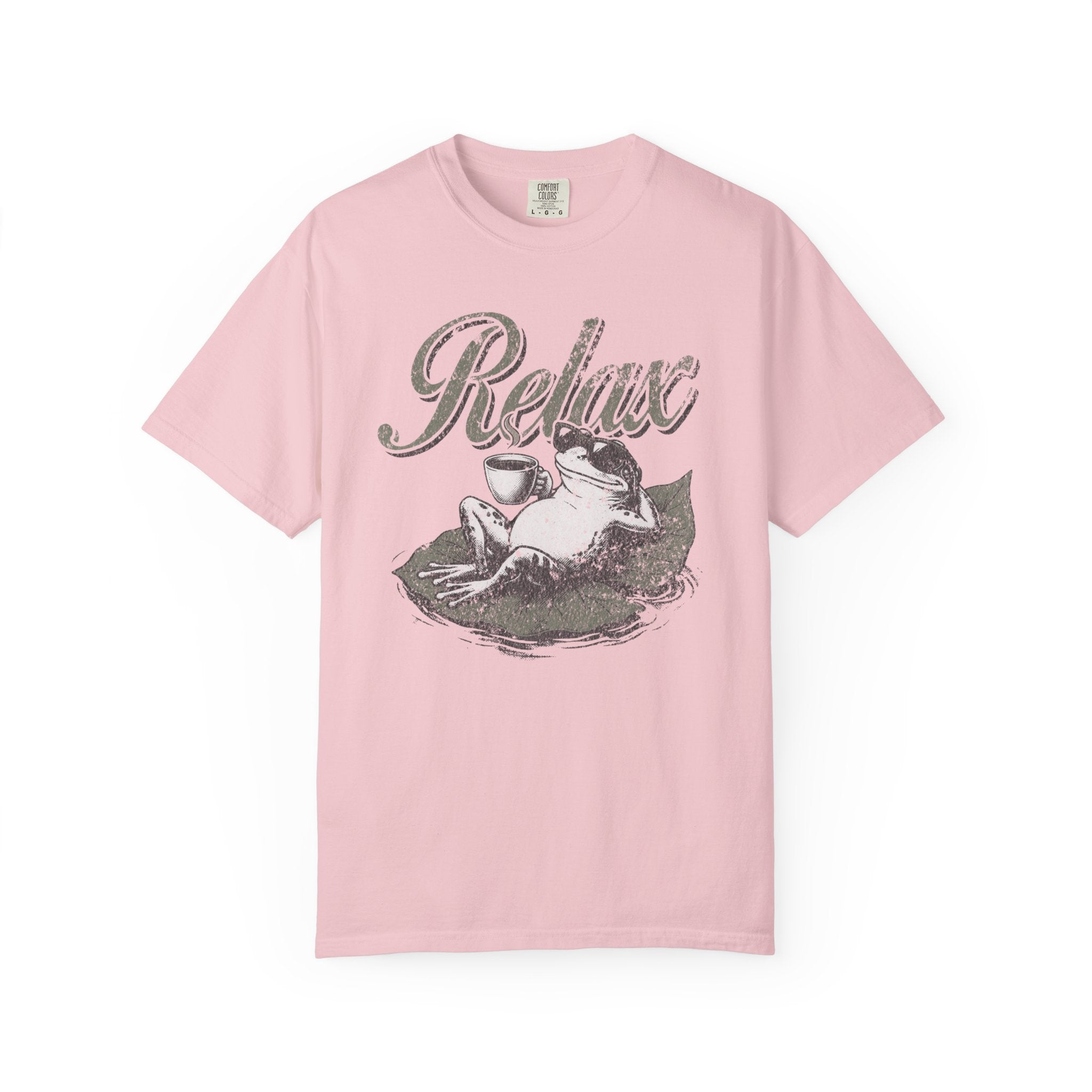 Light pink unisex t-shirt featuring a distressed graphic of a frog wearing sunglasses on a lily pad.
