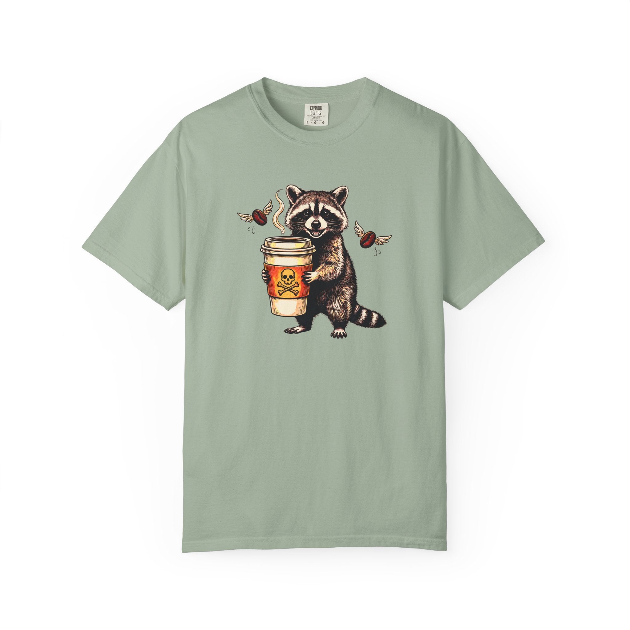 Sage green Comfort Colors 1717 unisex t-shirt featuring a raccoon holding a coffee cup with a skull.