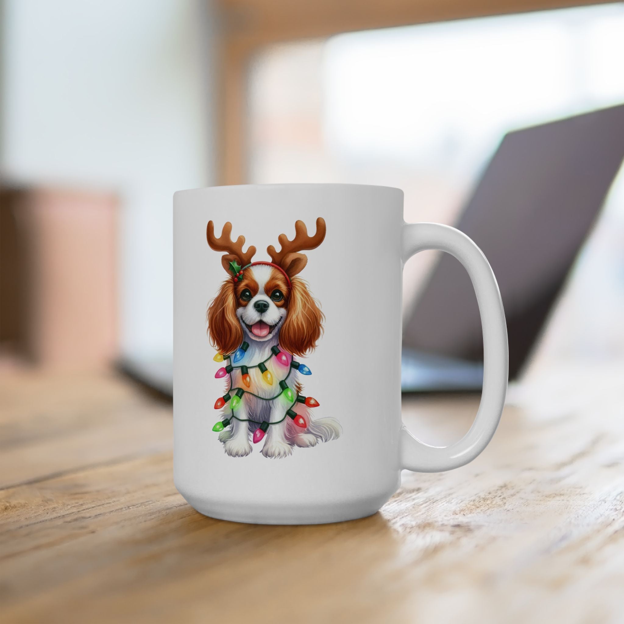 White ceramic mug with a Cavalier King Charles Spaniel wearing reindeer antlers and Christmas lights.
