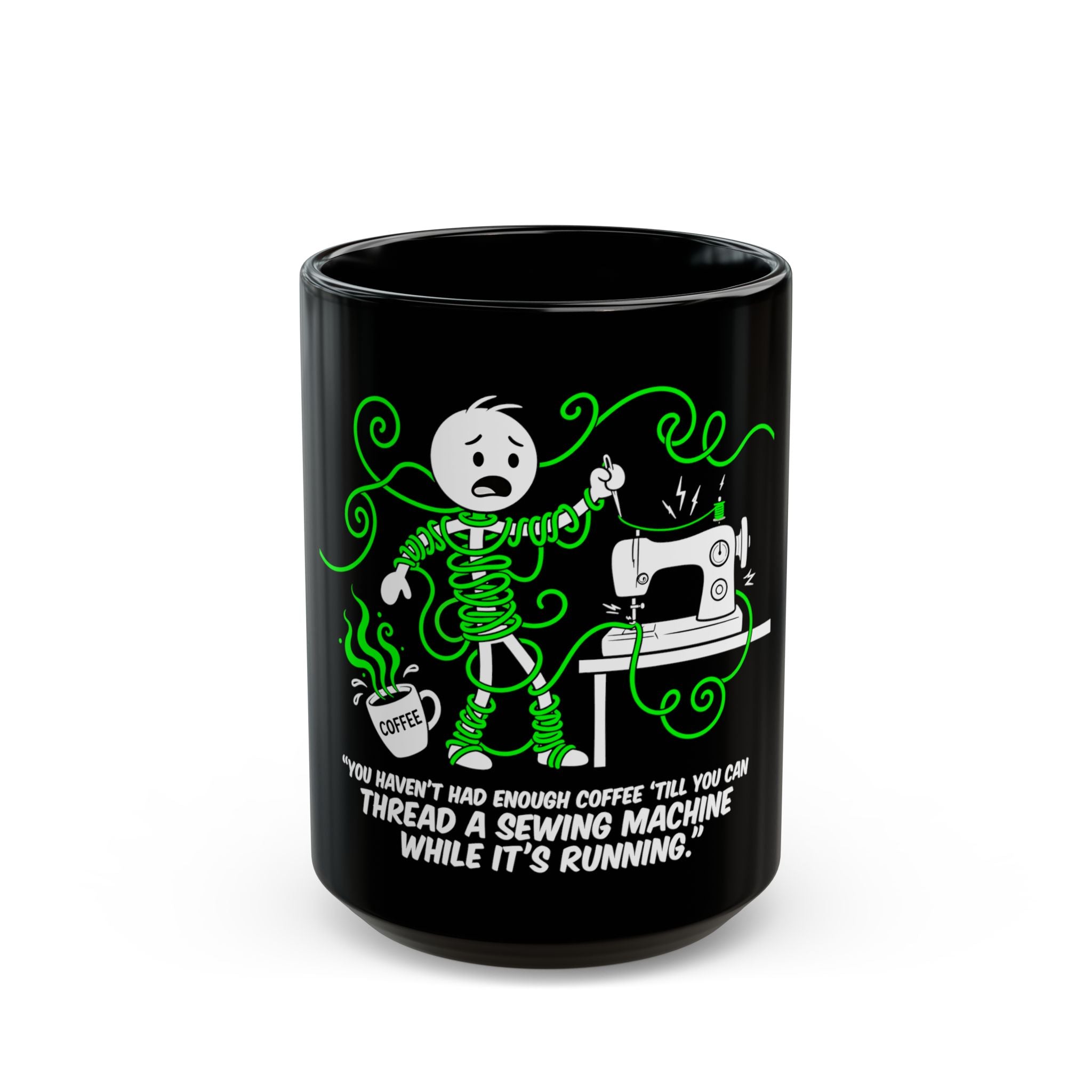 Black ceramic coffee mug with a cartoon of a person tangled in green thread by a sewing machine.