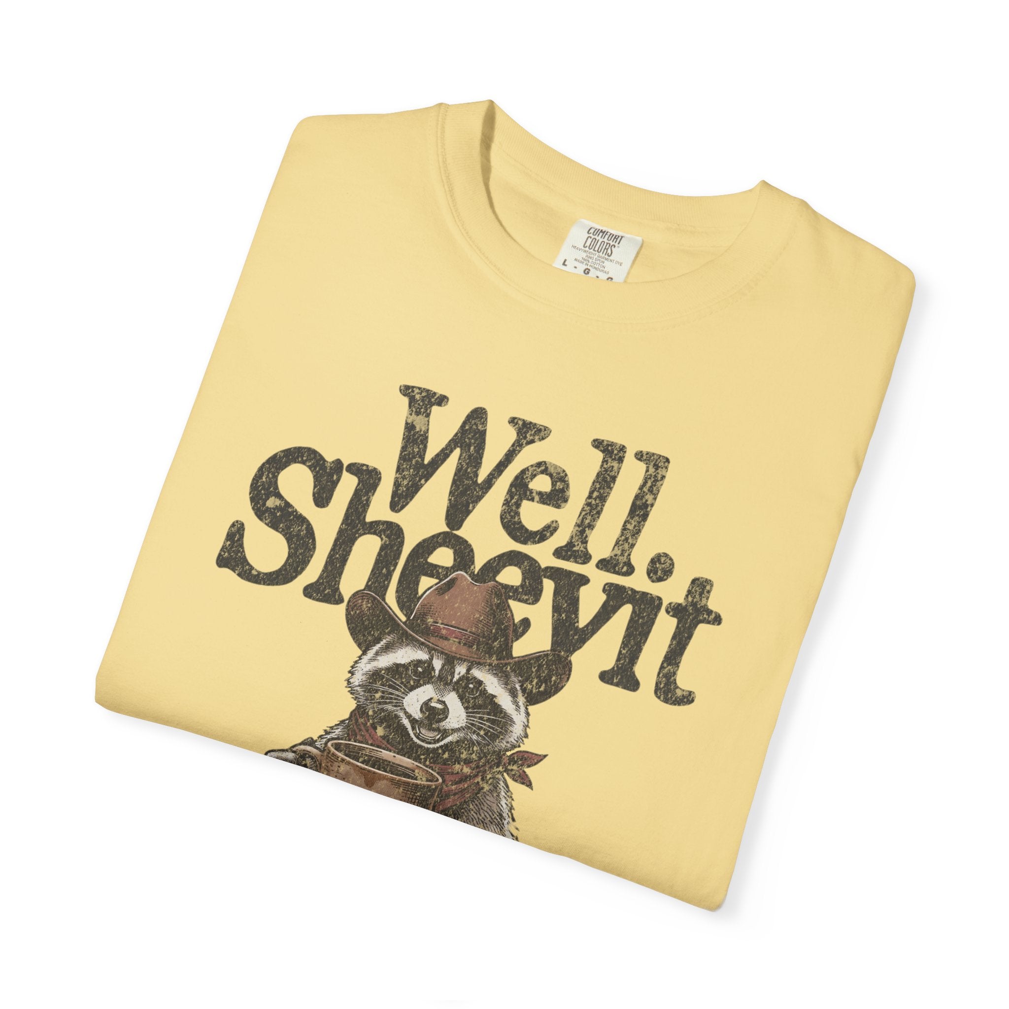 Light yellow t-shirt featuring a distressed graphic of a raccoon in a cowboy hat holding coffee.