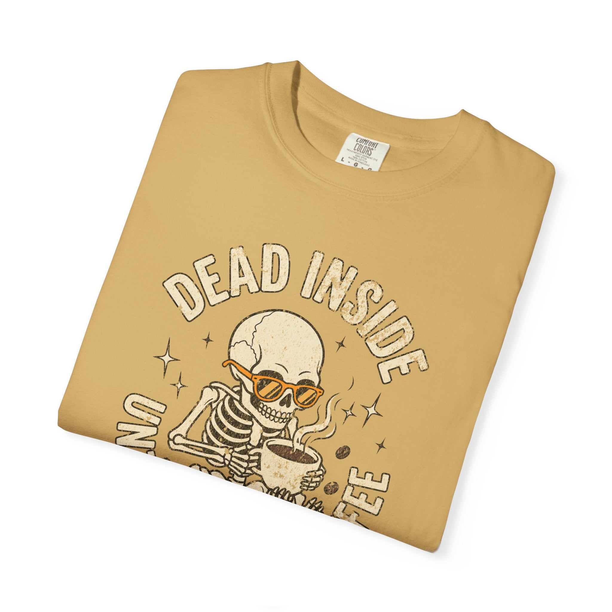 Tan t-shirt with a distressed graphic of a skeleton wearing sunglasses and holding a coffee mug.