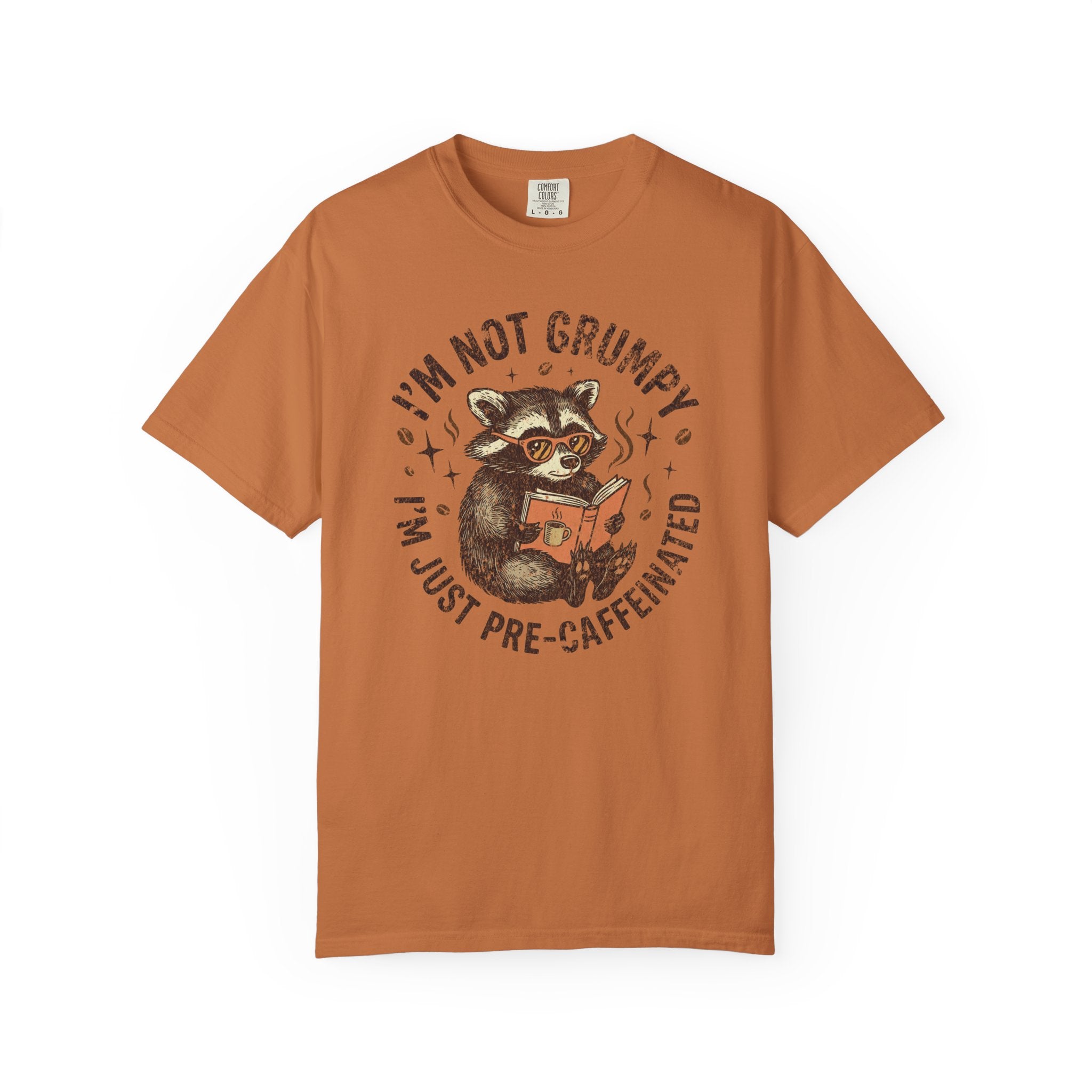 Rust-colored unisex t-shirt featuring a raccoon wearing glasses and reading a book.