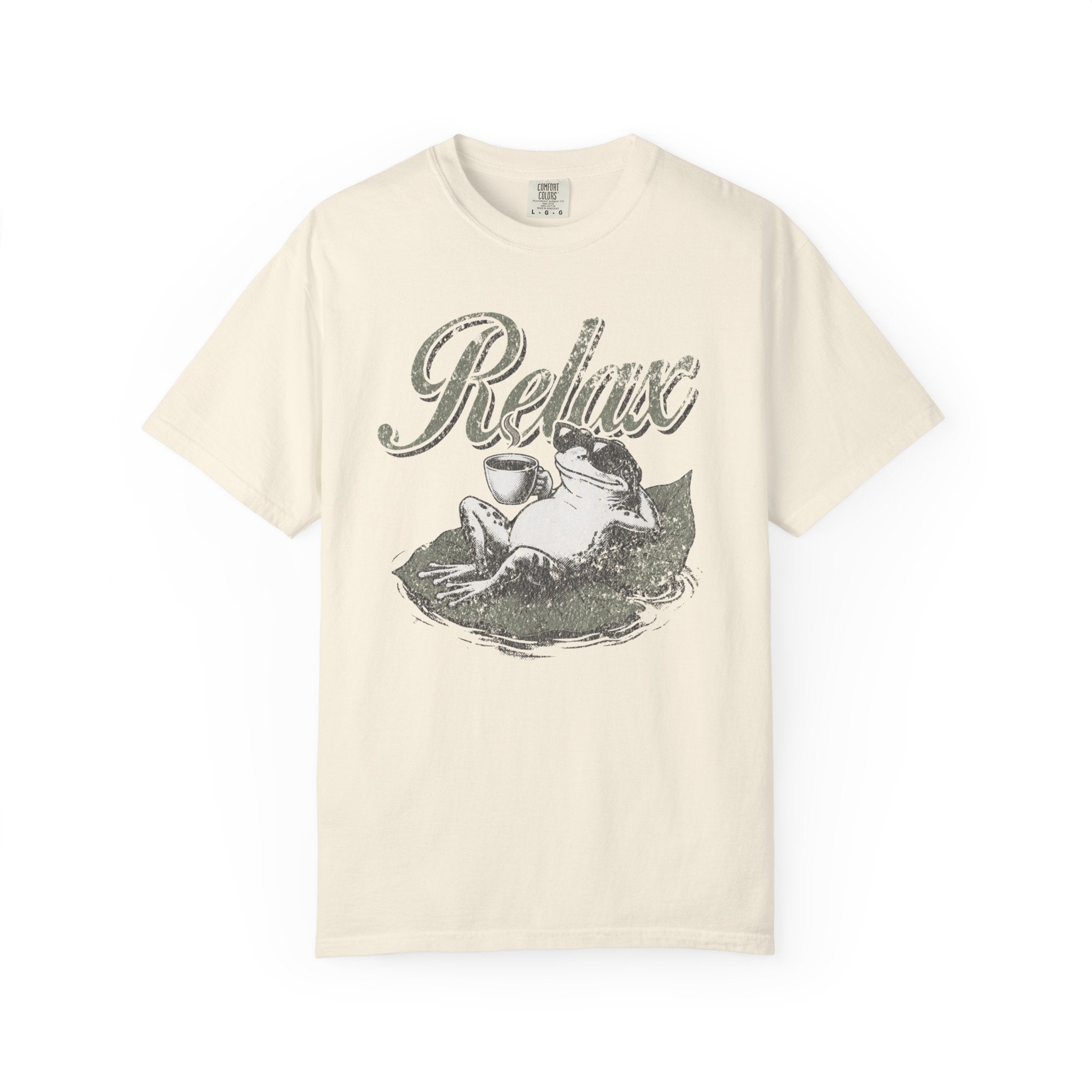 Cream-colored unisex t-shirt featuring a distressed graphic of a frog relaxing on a lily pad.