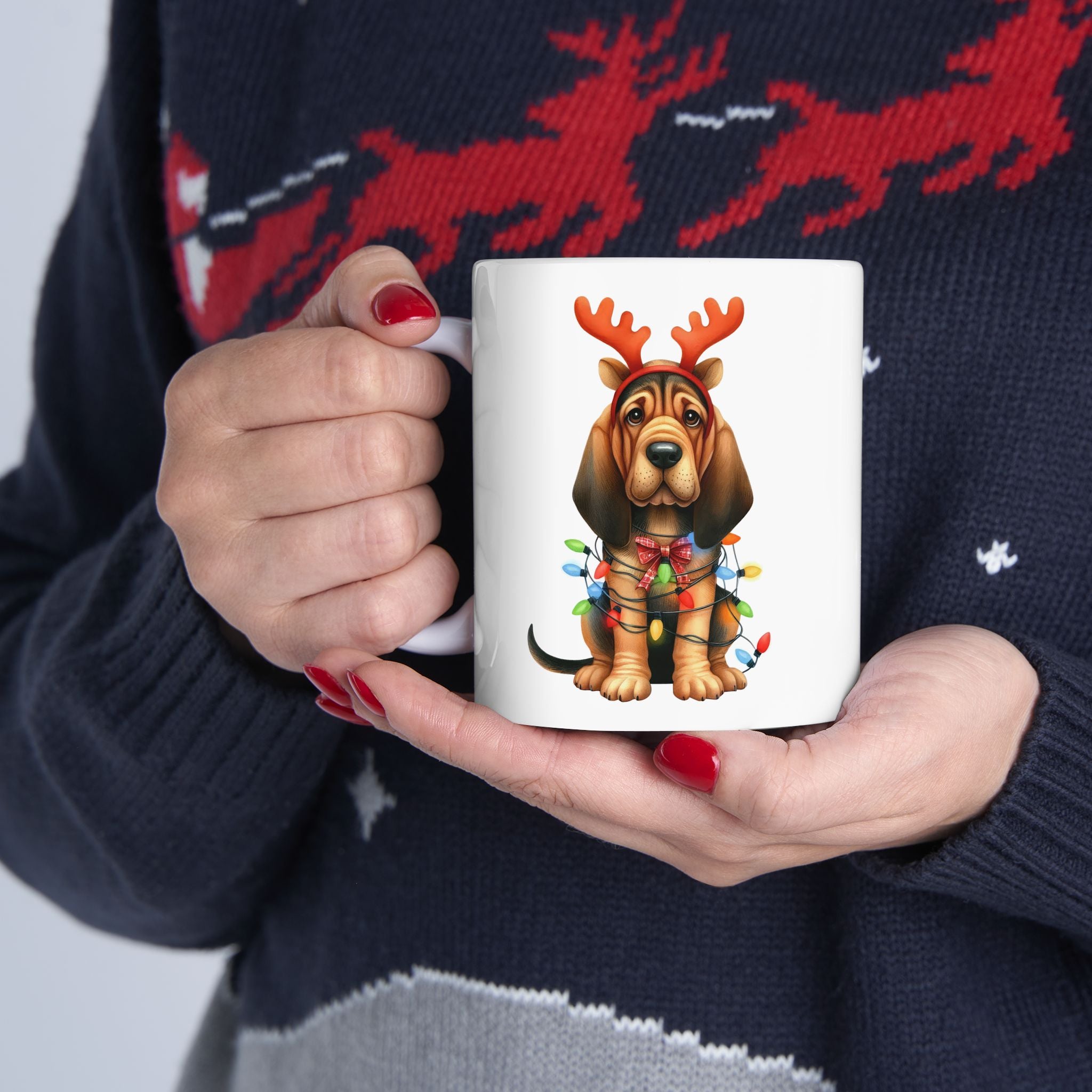 A white mug with a bloodhound wearing reindeer antlers and Christmas lights.