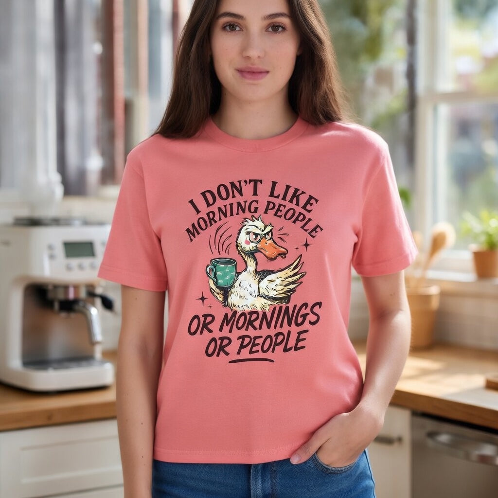 A woman wearing a pink t-shirt with a grumpy duck holding a coffee mug and funny text.
