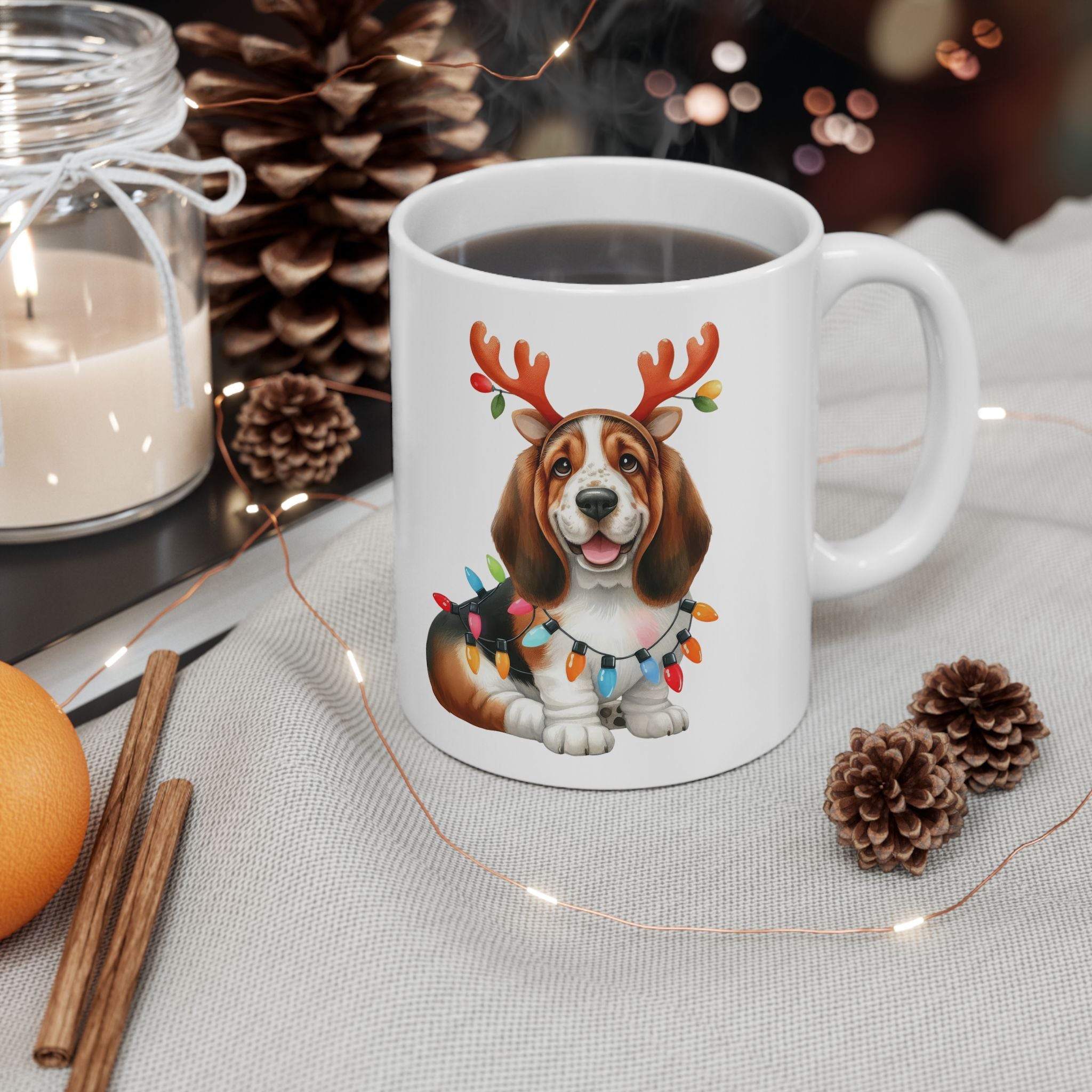 A white ceramic mug with a basset hound wearing reindeer antlers and Christmas lights.