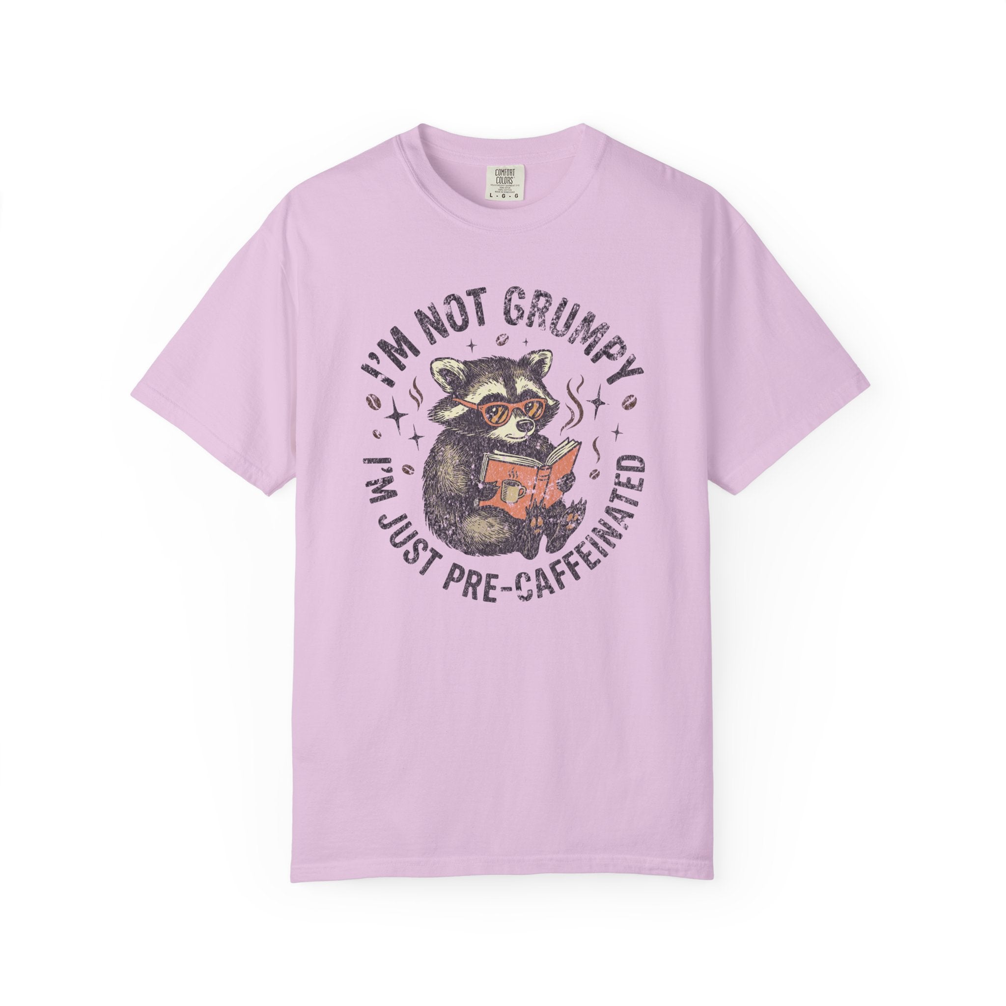 Light purple unisex t-shirt featuring a graphic of a raccoon wearing glasses and reading a book.
