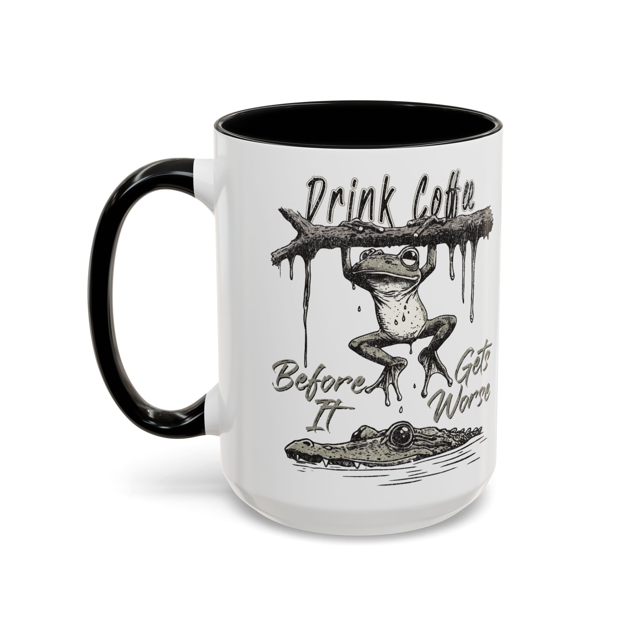 White ceramic mug with black handle and rim, featuring a frog hanging from a branch over a gator.