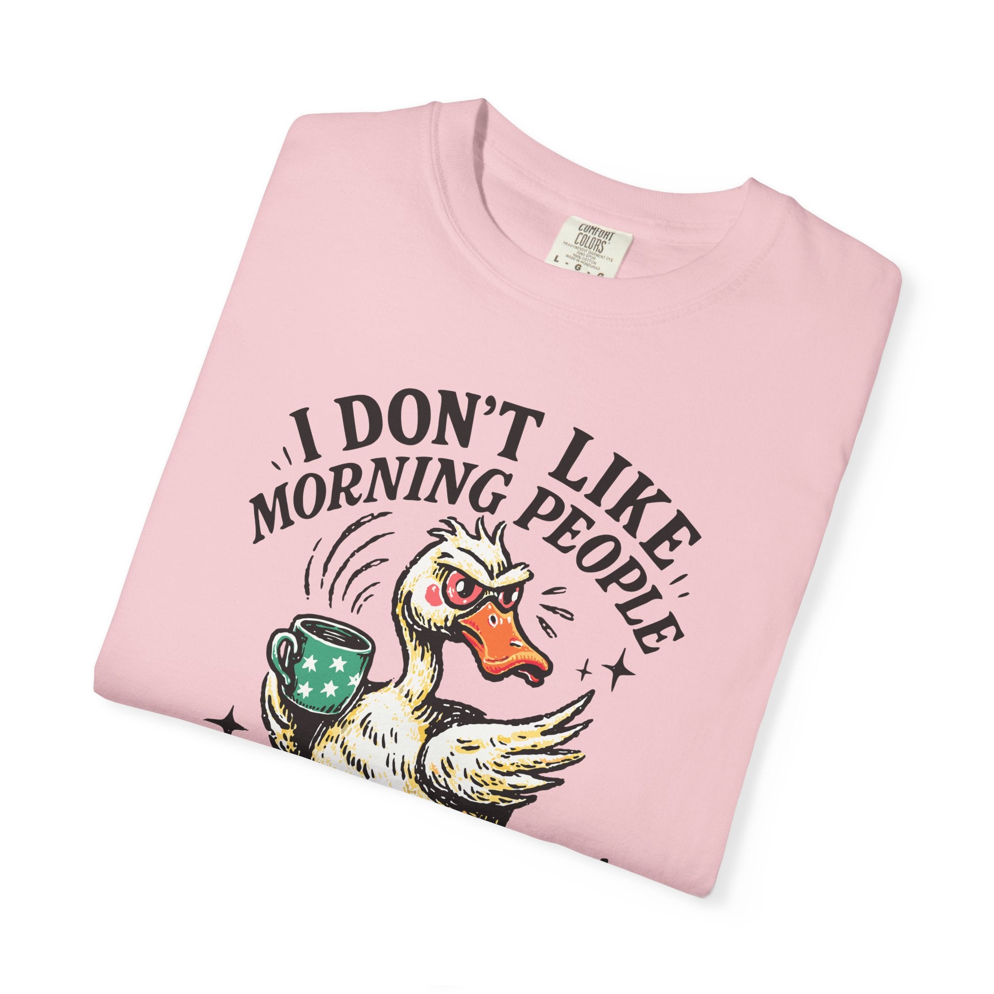 A pink t-shirt featuring a graphic of an angry duck holding a coffee mug with the text above it.