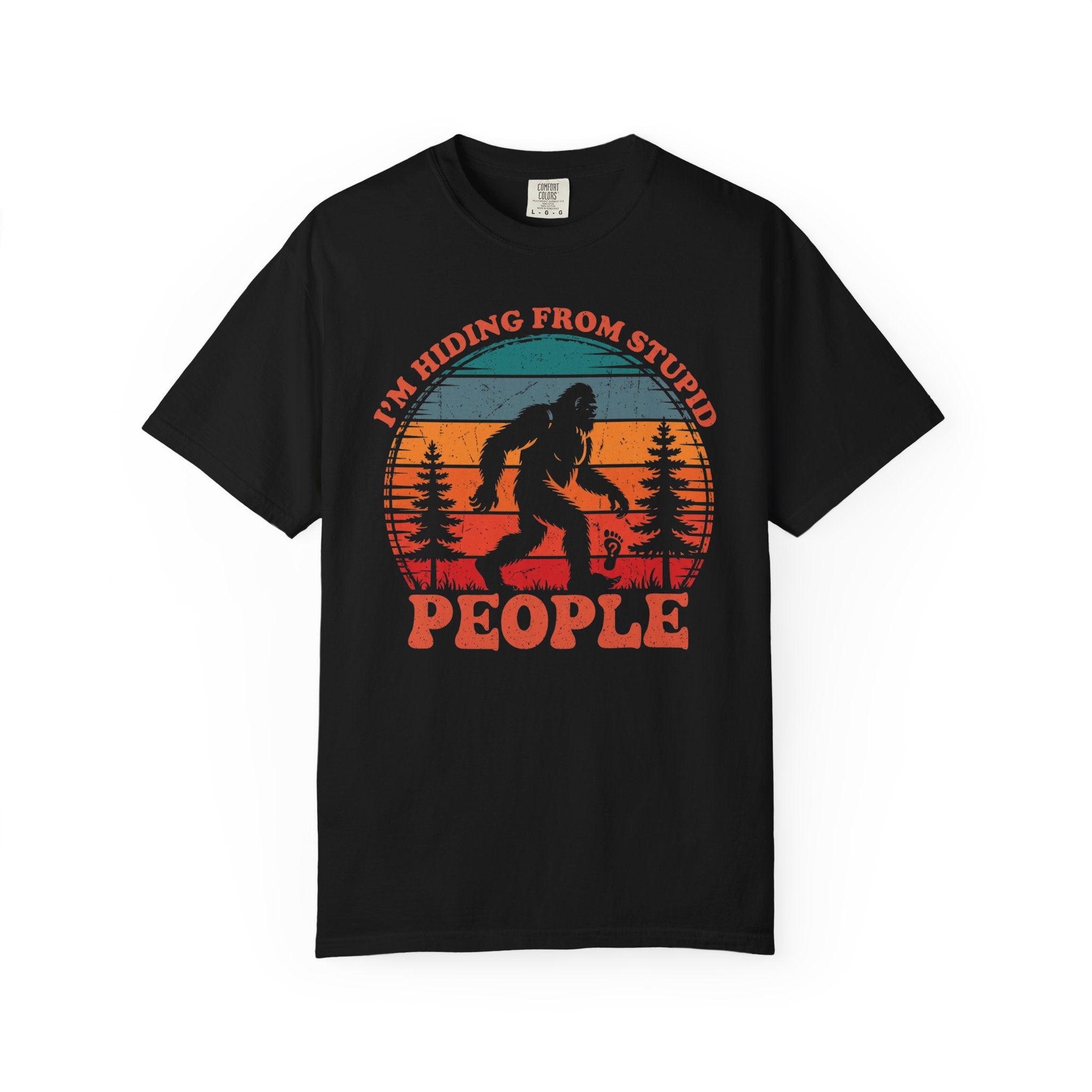 A black t-shirt featuring a vintage-style graphic of Bigfoot with the text I'm Hiding From Stupid People.