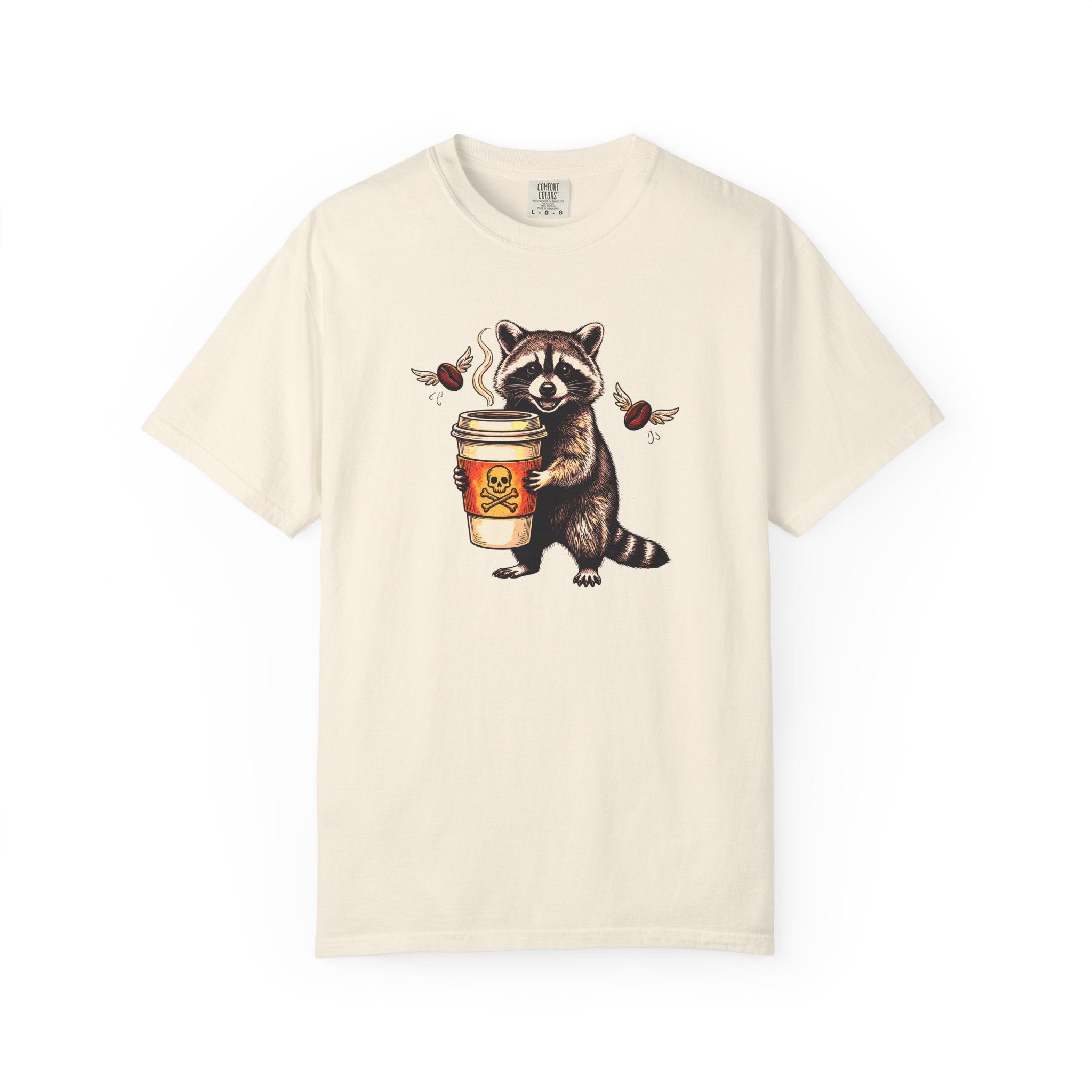 Cream-colored Comfort Colors unisex t-shirt featuring a graphic of a raccoon holding a coffee cup.