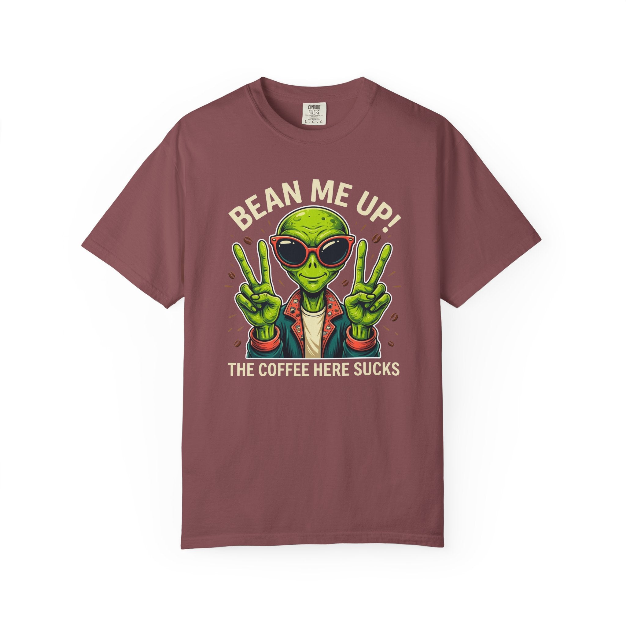 A maroon t-shirt featuring a green alien wearing sunglasses and making peace signs.