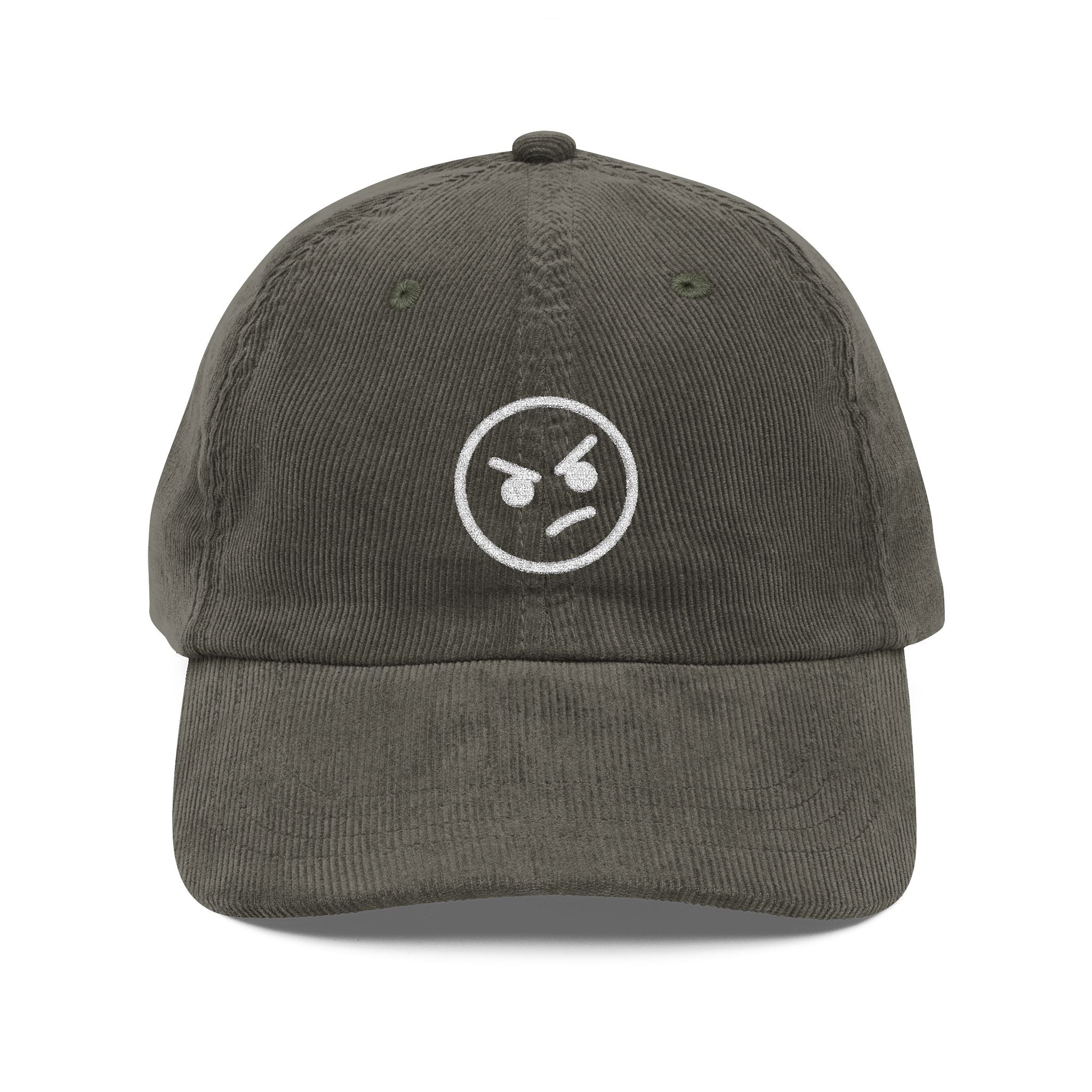 A mocha brown corduroy dad hat featuring an embroidered white angry face emoji on the front.