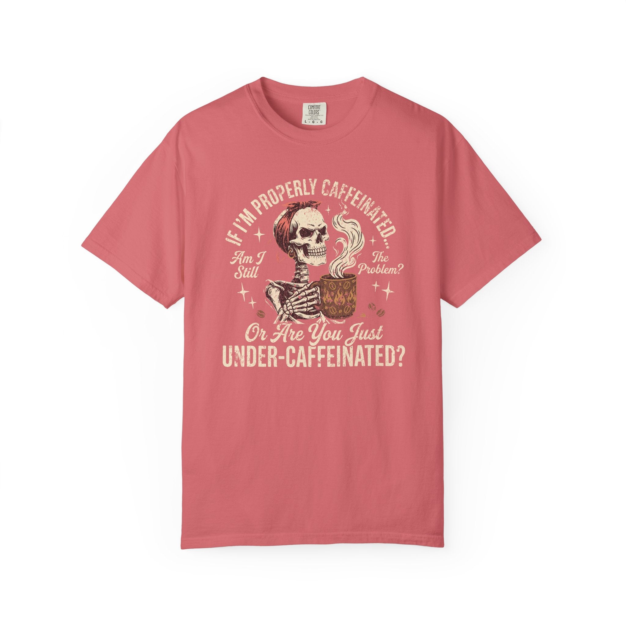 A coral-colored t-shirt featuring a graphic of a skeleton holding a steaming mug of coffee.