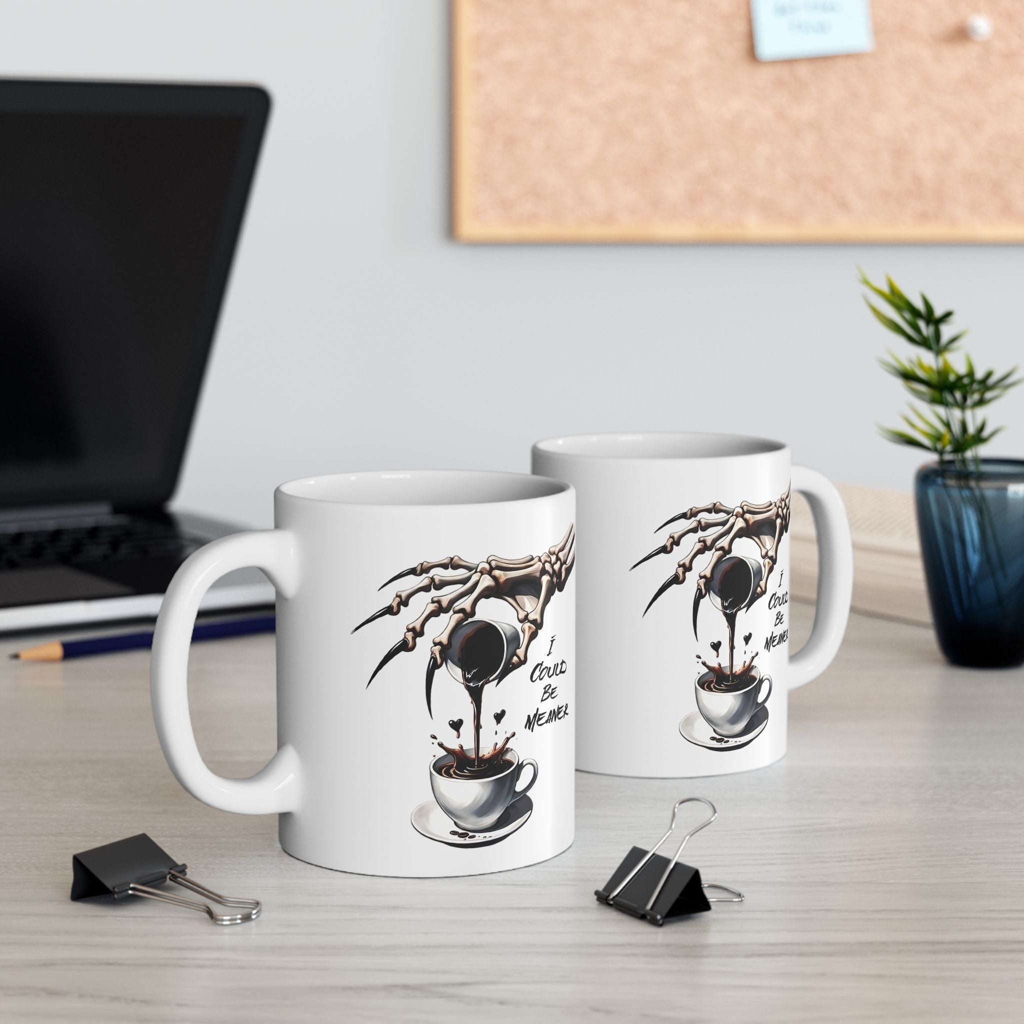 A white ceramic mug with a skeleton hand pouring coffee and the text "I Could Be Meaner".