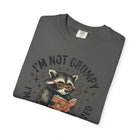 A dark gray t-shirt featuring a graphic of a raccoon wearing glasses and reading a book.