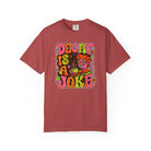 A red t-shirt featuring a retro psychedelic graphic that reads Decaf Is A Joke.