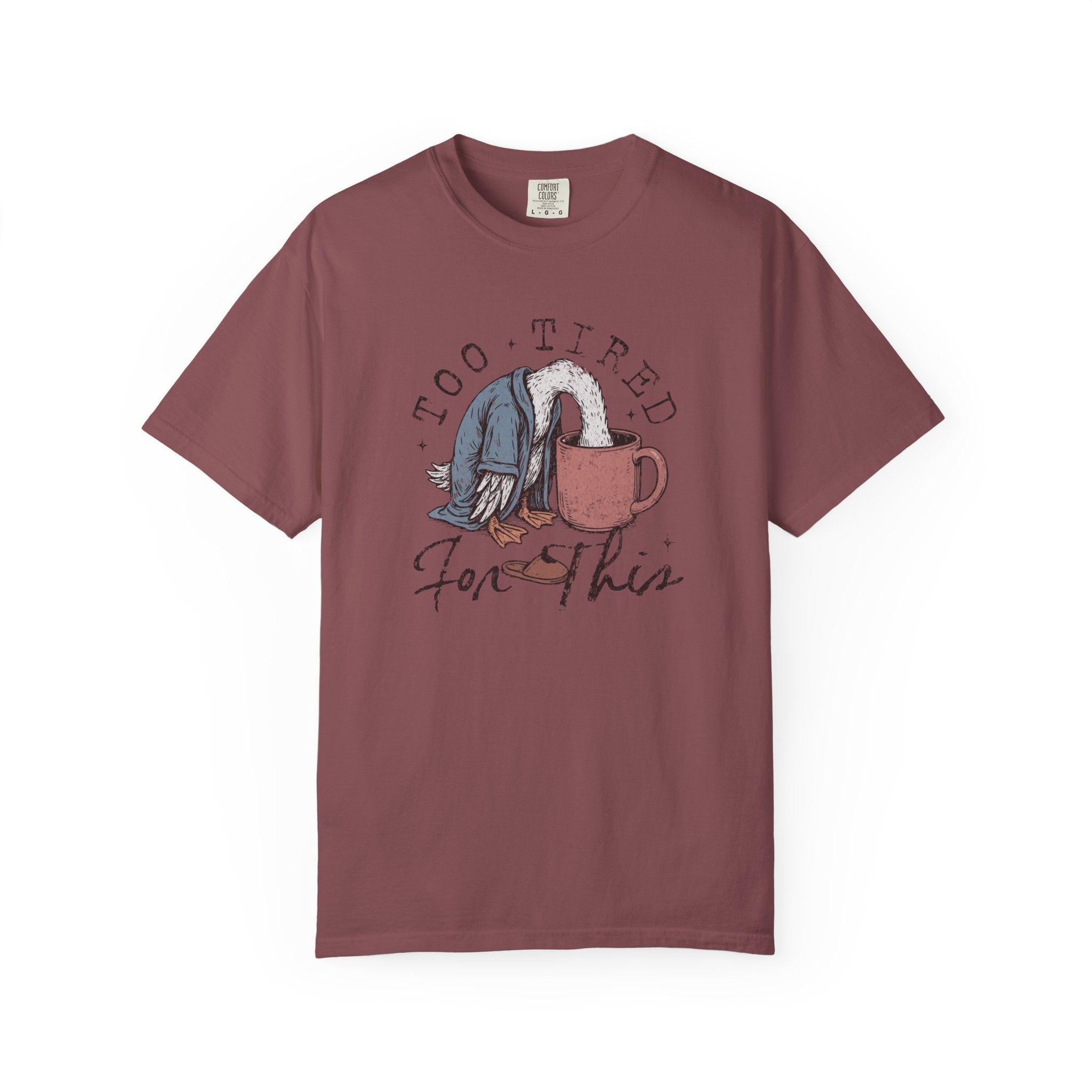 A maroon unisex t-shirt featuring a graphic of a duck with its head in a coffee mug.