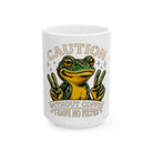 White mug featuring a cartoon frog making peace signs with the text Caution Without Coffee No Filter