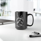 Black mug with text on a desk with office items