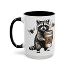 White ceramic mug with a black handle featuring a raccoon holding a coffee cup with flying beans.