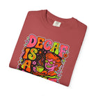 Folded red t-shirt featuring a retro psychedelic graphic with the text Decaf Is A Joke.