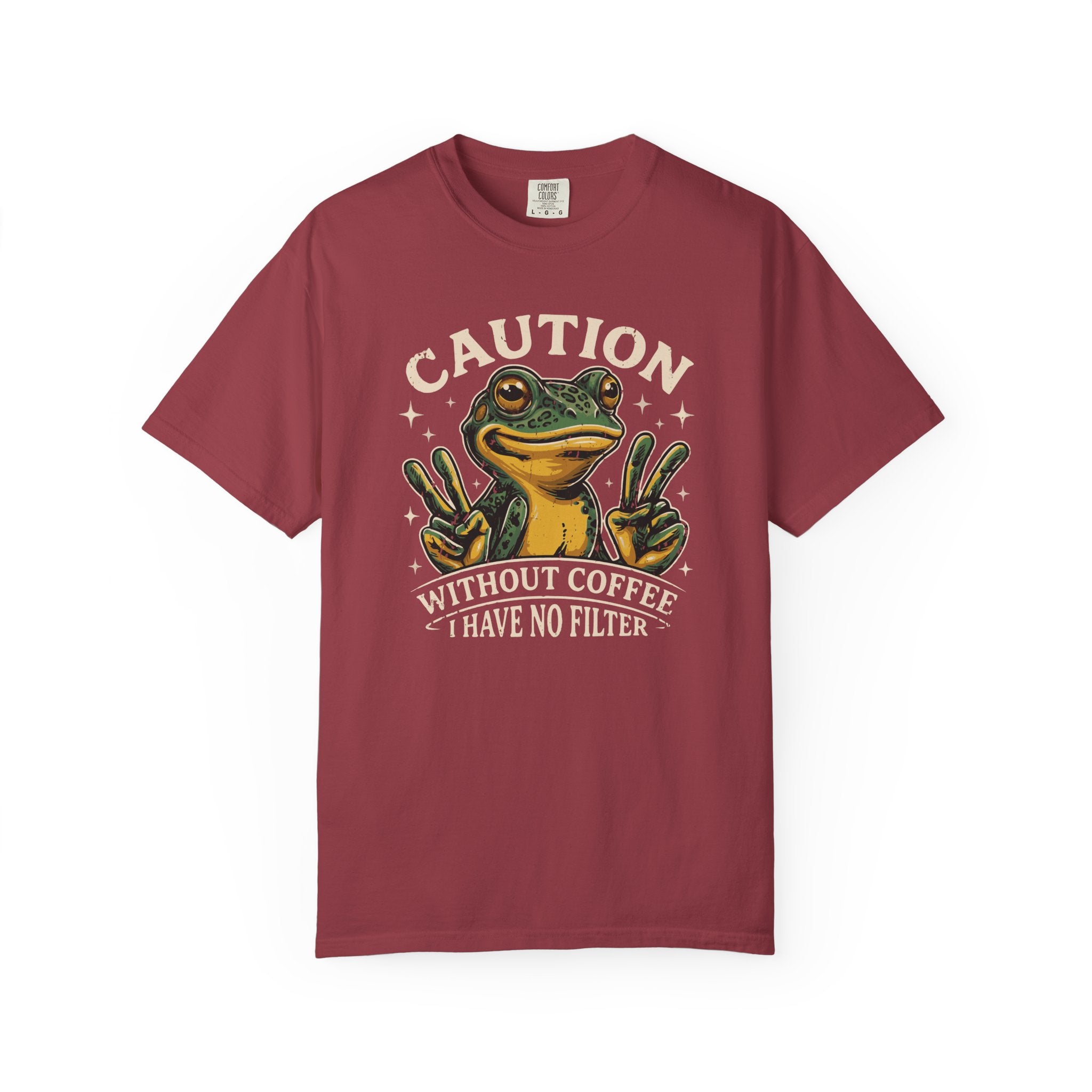 A maroon t-shirt featuring a graphic of a frog making peace signs with the text about coffee.