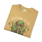 A tan unisex cotton t-shirt featuring a distressed graphic of an alien wearing sunglasses.