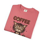 A folded pink unisex cotton t-shirt featuring a graphic of a fluffy kitten and the word COFFEE.