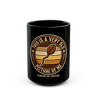 Black ceramic coffee mug with a vintage-style graphic of a coffee bean shaped like a sperm cell.
