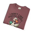 A maroon t-shirt featuring a graphic of an angry duck holding a coffee mug with the text above.