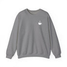 A grey crewneck sweatshirt featuring a small white steaming coffee cup icon on the left chest.