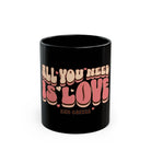 Black ceramic mug featuring the retro 70s style text All You Need Is Love and Coffee.