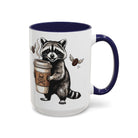 White ceramic mug with a blue handle and interior, featuring a raccoon holding a coffee cup.