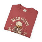 Red t-shirt with a distressed graphic of a skeleton wearing sunglasses and drinking coffee.