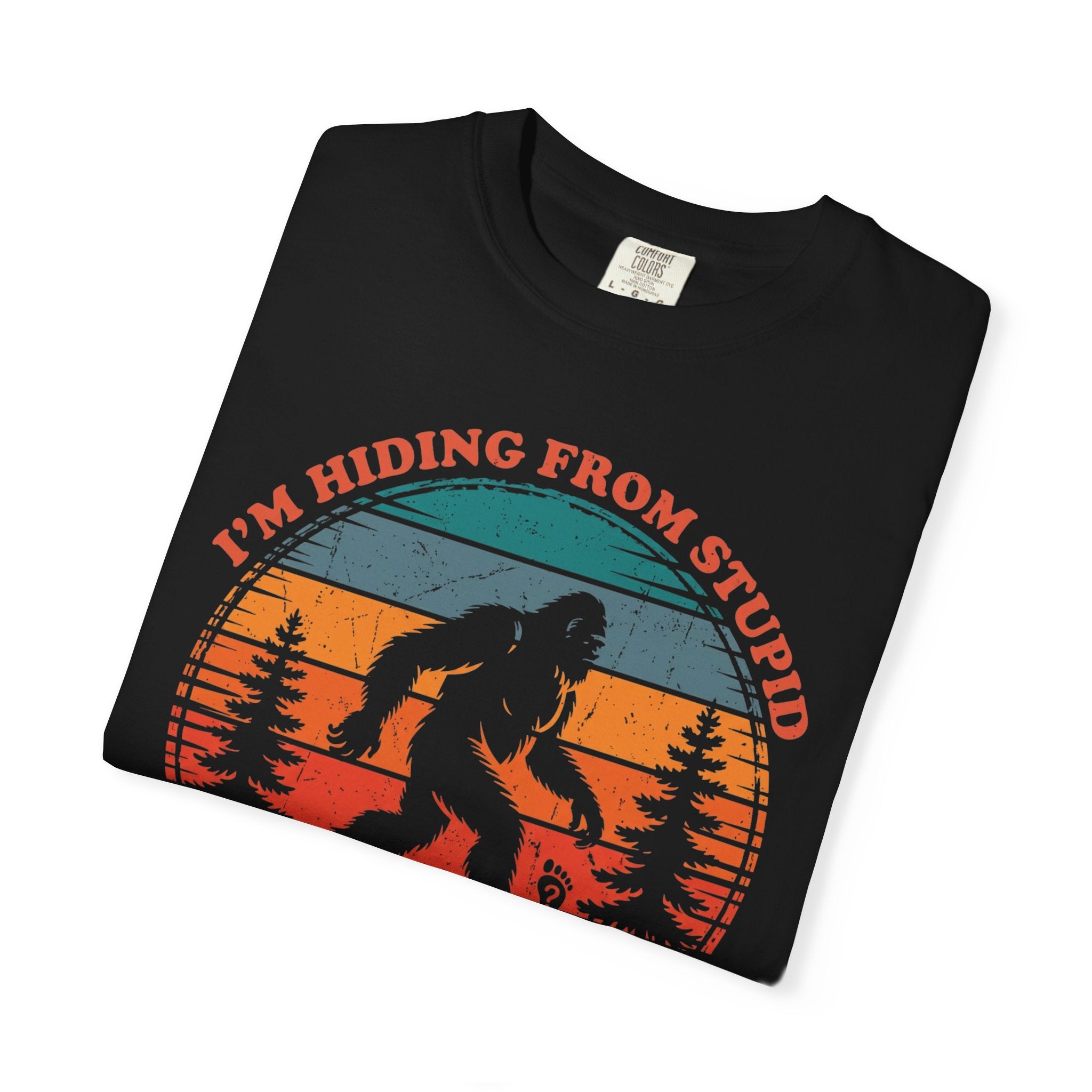 A black t-shirt featuring a vintage-style graphic of Bigfoot in a forest with the text I'm Hiding.