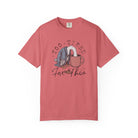 A coral-colored unisex t-shirt with a graphic of a duck with its head in a coffee mug.
