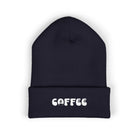 A navy blue cuffed beanie with white embroidered "COFFEE" text.