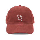 A rust-colored corduroy dad hat featuring an embroidered white coffee bean icon on the front.