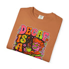 Folded orange t-shirt with a retro psychedelic graphic featuring a person drinking coffee.