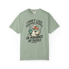 Sage green t-shirt with a graphic of an angry duck holding a coffee mug and text.
