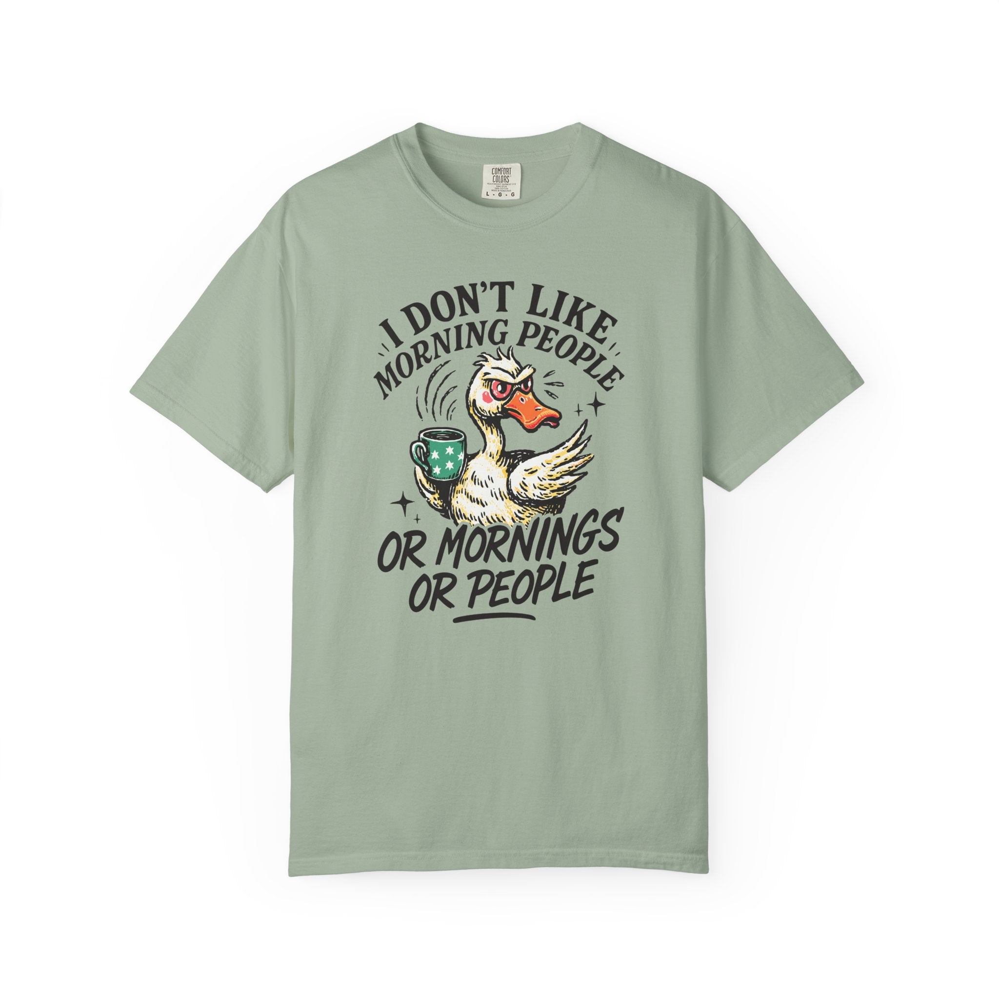 Sage green t-shirt with a graphic of an angry duck holding a coffee mug and text.