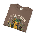 Brown t-shirt featuring a green frog graphic making peace signs with the text CAUTION above it.