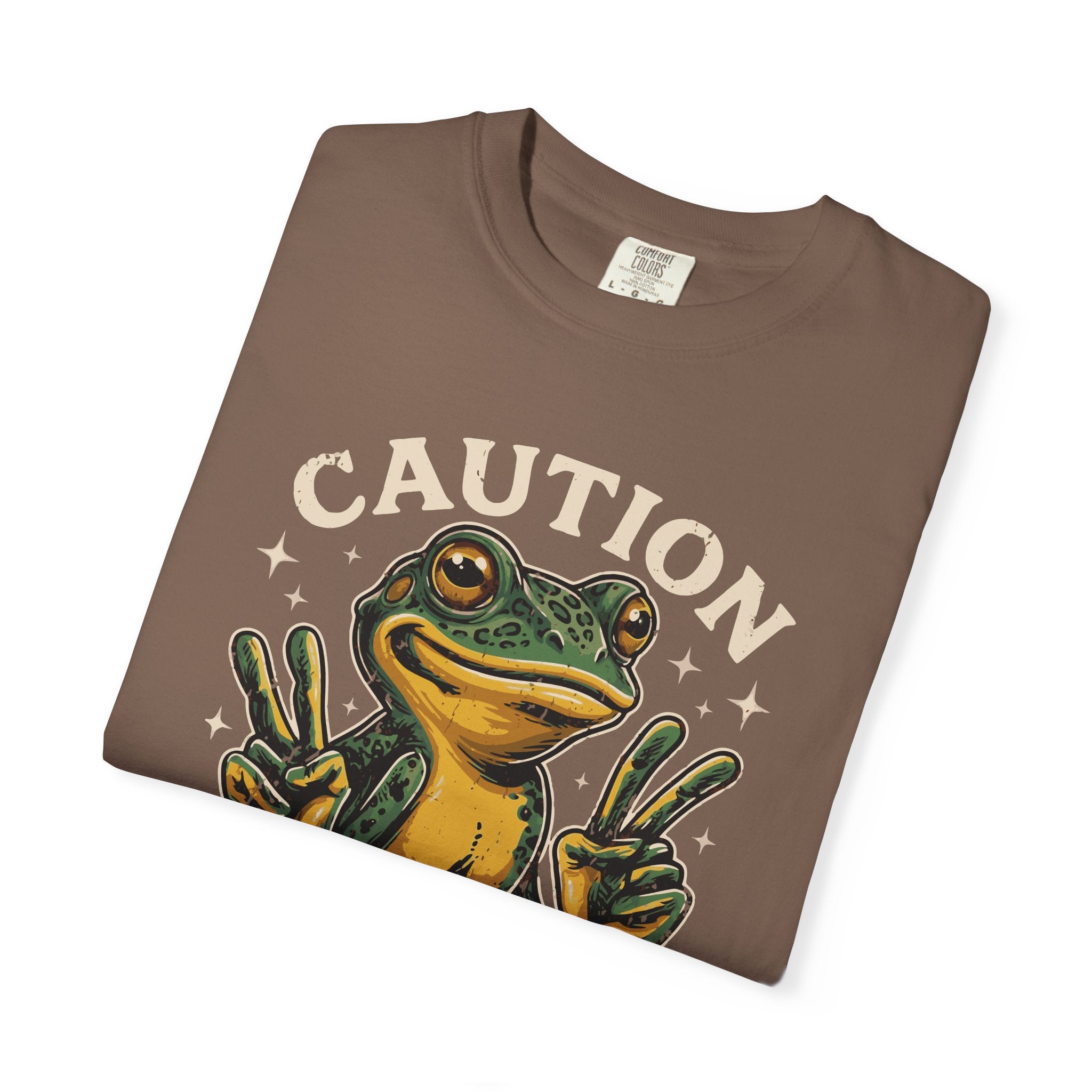 Brown t-shirt featuring a green frog graphic making peace signs with the text CAUTION above it.