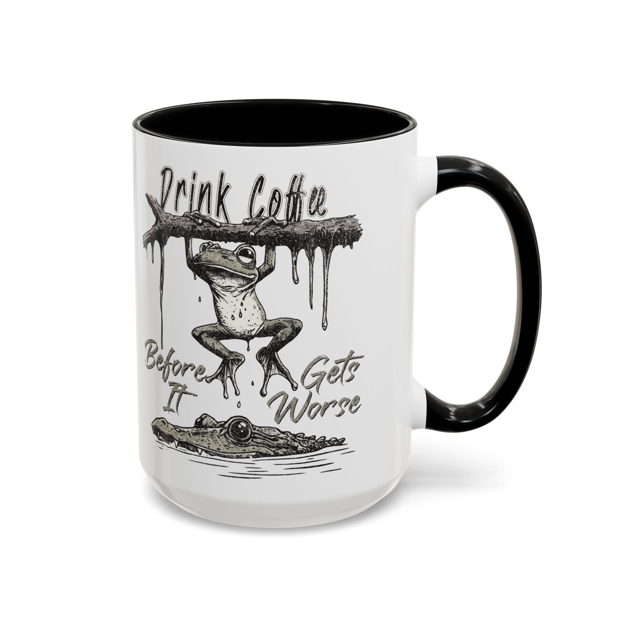 White ceramic mug with a black handle and rim, featuring a frog hanging from a branch over a gator.