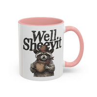 A white ceramic mug with a pink rim and handle, featuring a raccoon in a cowboy hat holding a cup.